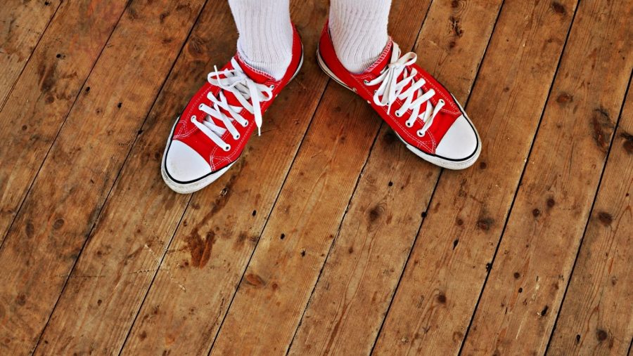 Žmogus stovi ant medinių grindų karkasiniame name – tvirtos ir kokybiškos medinės perdangos pavyzdys.