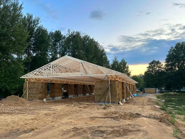 „Husline“ medinės santvaros užtikrina tvirtą stogą tvariam šiaudiniam pastatui projekte „Kardokai“.